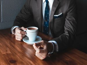 A businessman in a suit drinking coffee.