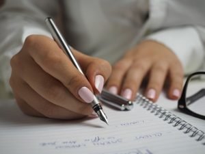 A woman writing a list.