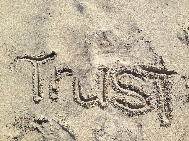 Trust word written in the sand